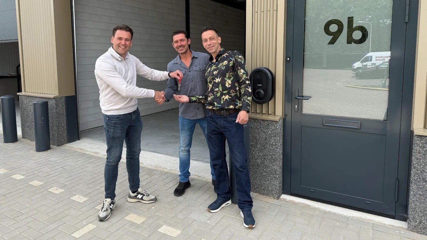 drie mannen waarvan er 1 aan de anderen een sleutel geeft